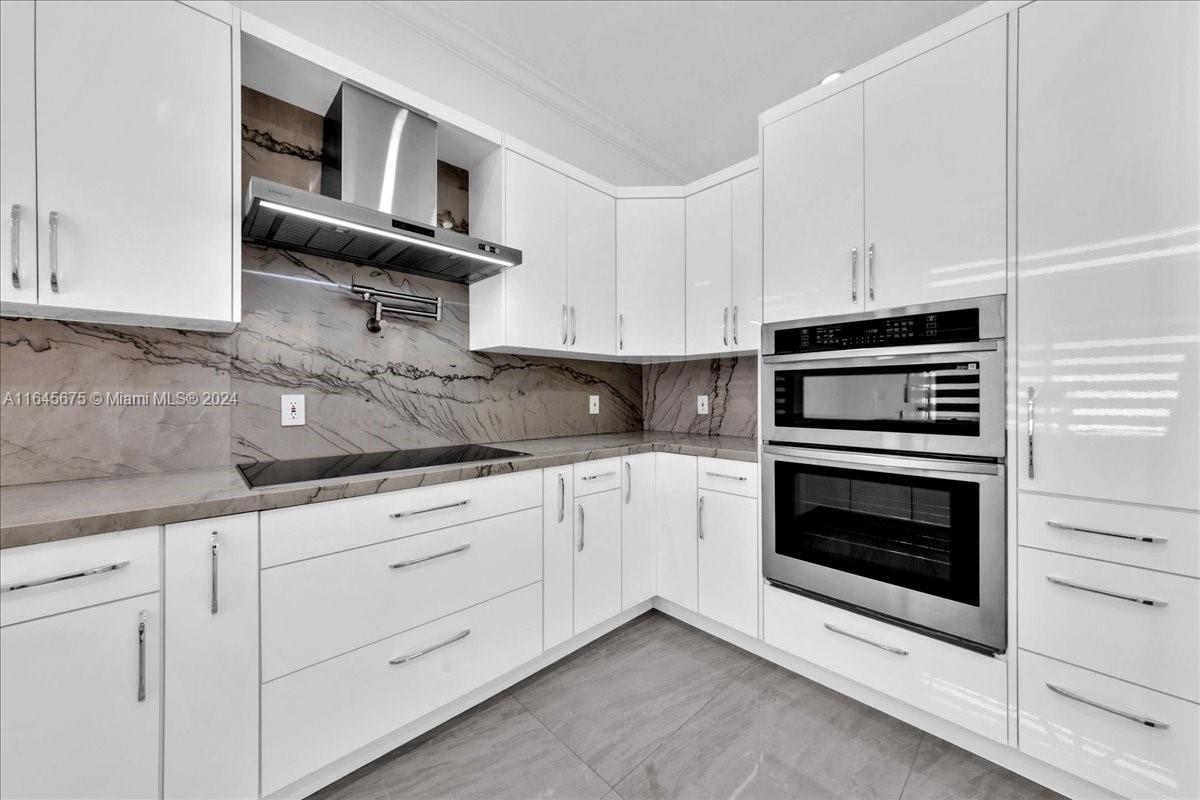2373 Southwest 177th Terrace Miramar, FL 33029 - Photo 41 of 79 a kitchen with granite countertop white cabinets and stainless steel appliances