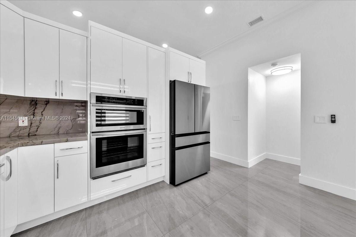 2373 Southwest 177th Terrace Miramar, FL 33029 - Photo 43 of 79 a kitchen with stainless steel appliances white cabinets and a refrigerator