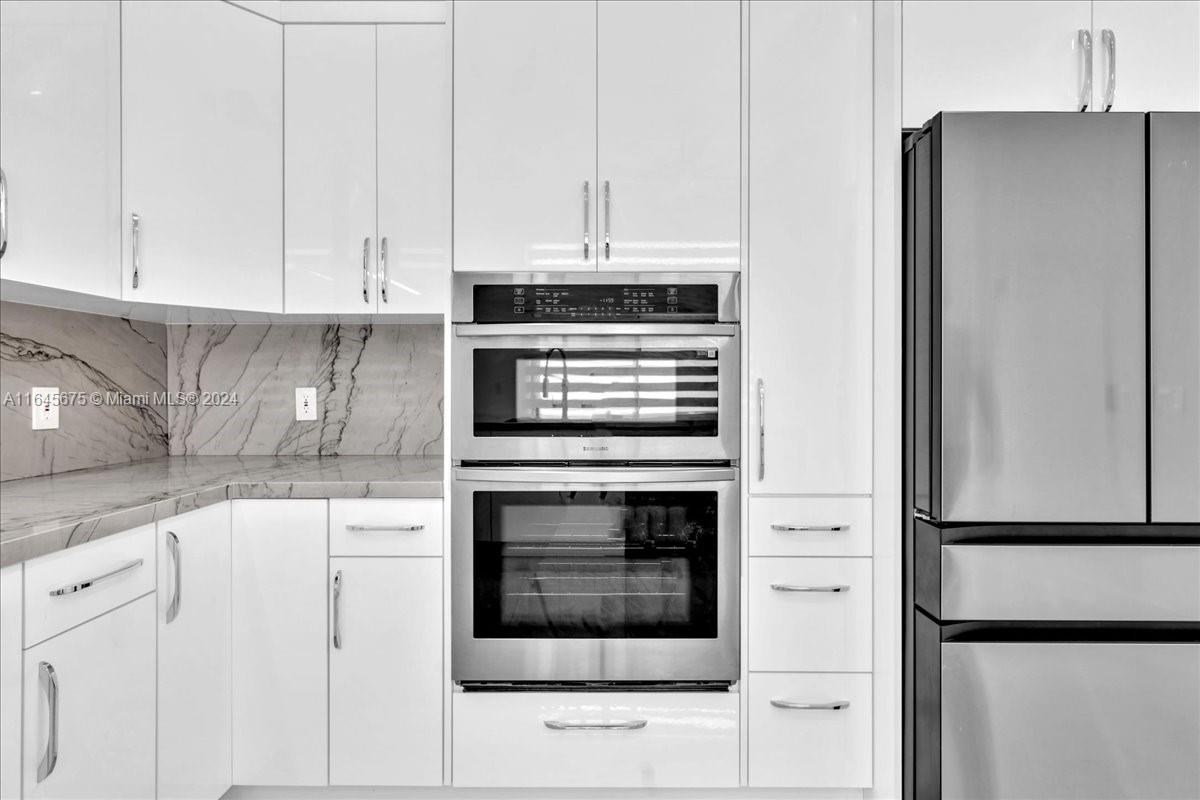 2373 Southwest 177th Terrace Miramar, FL 33029 - Photo 44 of 79 a kitchen with granite countertop white cabinets and stainless steel appliances