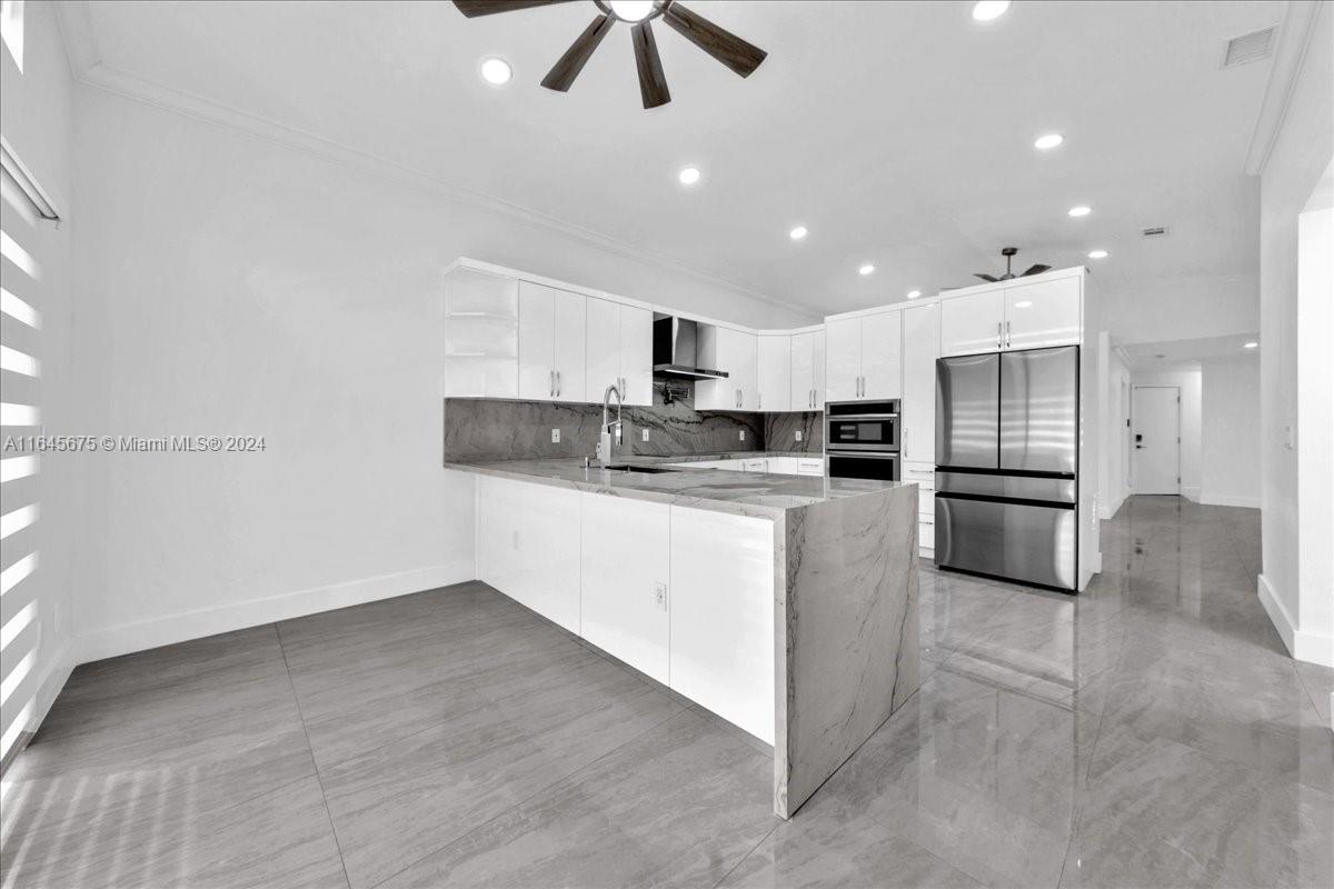 2373 Southwest 177th Terrace Miramar, FL 33029 - Photo 47 of 79 a kitchen with stainless steel appliances granite countertop a refrigerator a stove a sink and a oven