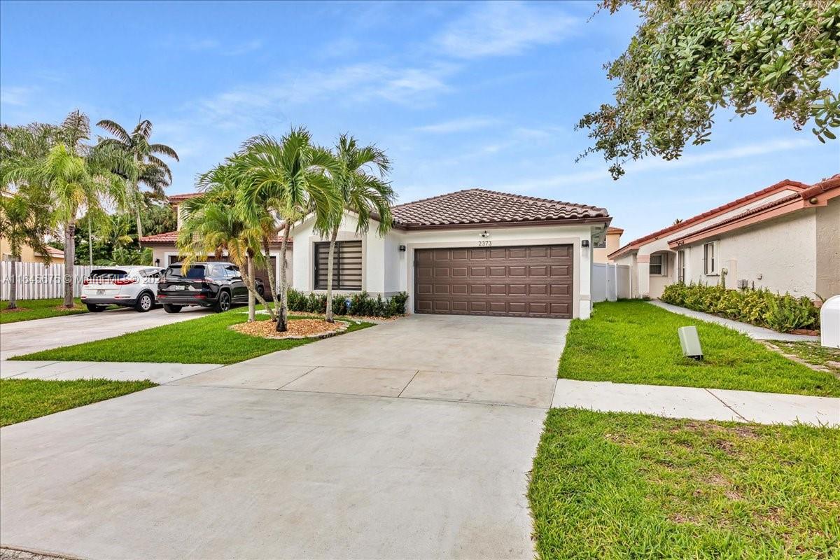 2373 Southwest 177th Terrace Miramar, FL 33029 - Photo 61 of 79 a front view of a house with a yard and garage