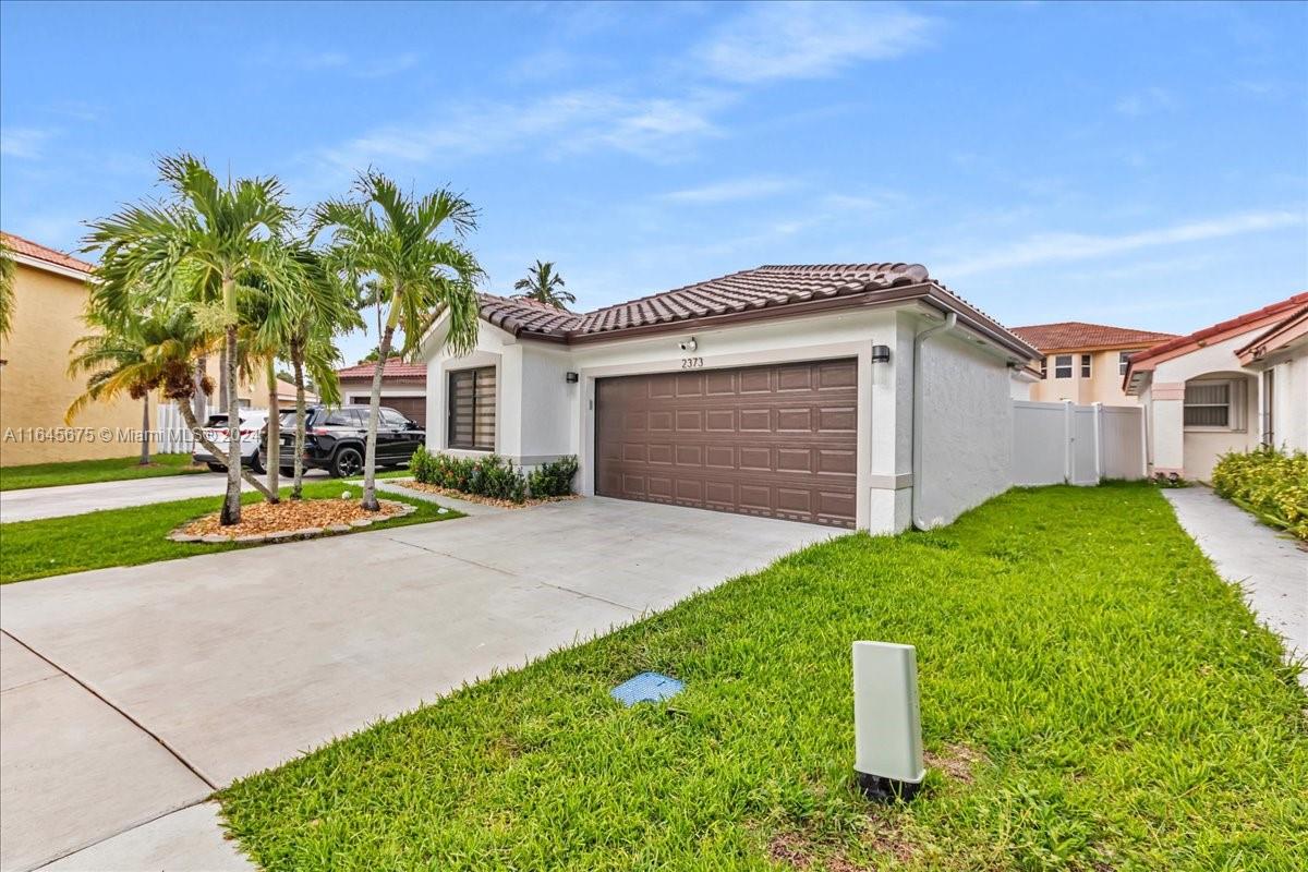 2373 Southwest 177th Terrace Miramar, FL 33029 - Photo 63 of 79 a front view of a house with a yard and garage