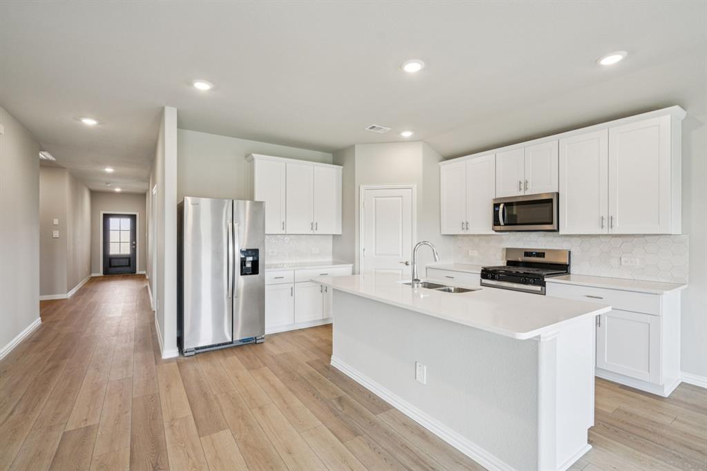 a kitchen with stainless steel appliances a refrigerator sink and microwave