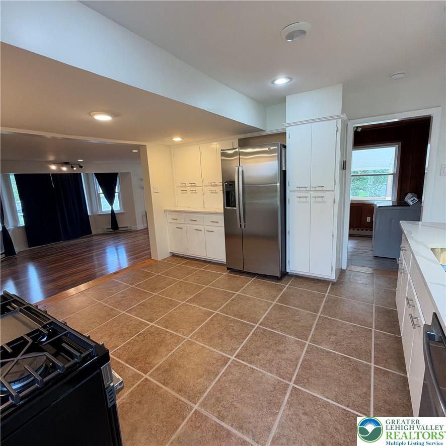 5111 Vera Cruz Road Emmaus, PA 18049 - Photo 19 of 44 Durable tile flooring meets classic white cabinetry in this functional, open-concept kitchen.