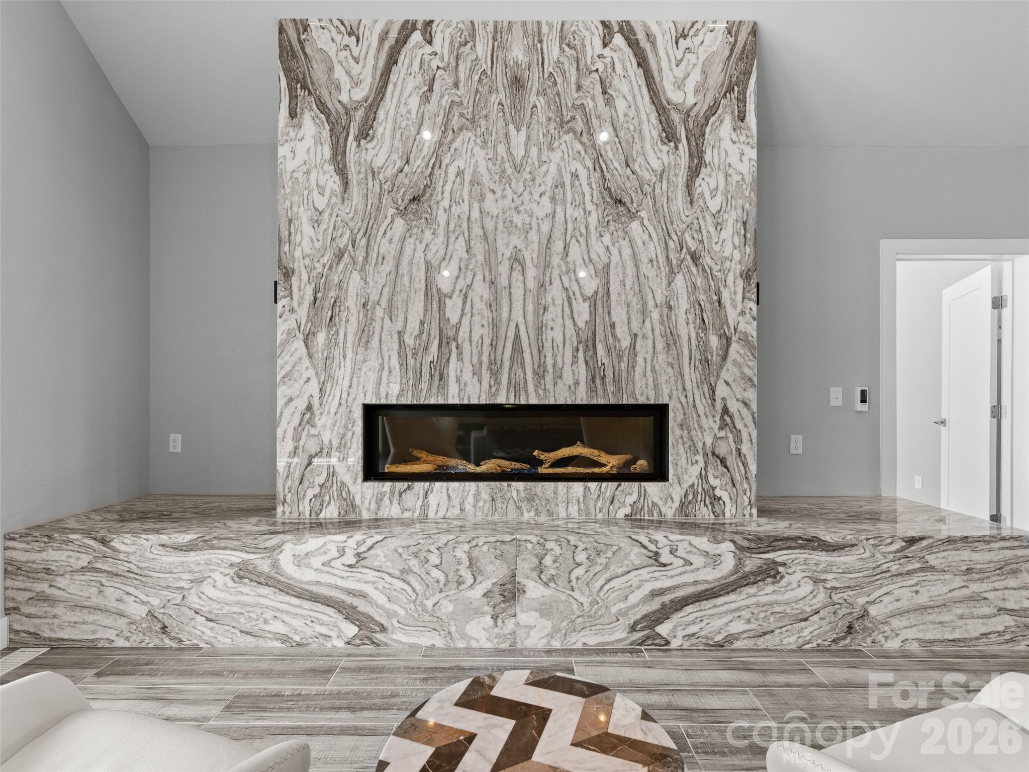 123 Israel Road Candler, NC 28715 - Photo 16 of 44 a room with a fireplace and a chandelier