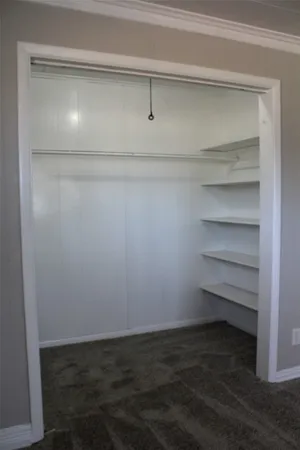 a view of walk in closet with empty racks