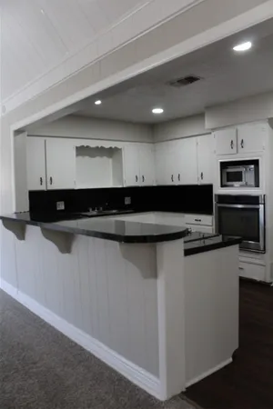 a view of kitchen with stainless steel appliances kitchen island sink refrigerator and microwave