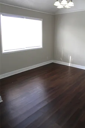 an empty room with windows and ceiling fan