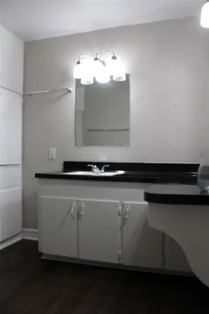 a close view of kitchen counter space with granite countertop cabinets and a wooden floor