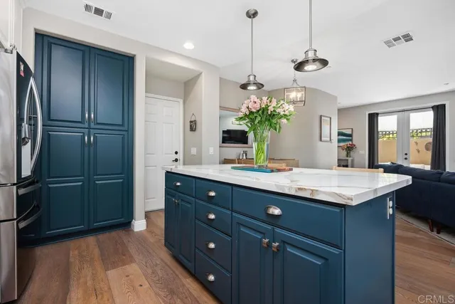 a kitchen with a refrigerator and countertop wooden cabinets