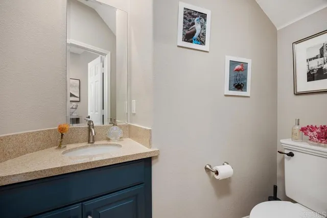 a bathroom with a sink mirror and toilet