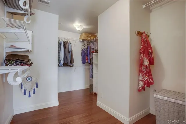a view of walk in closet with clothes and shoes