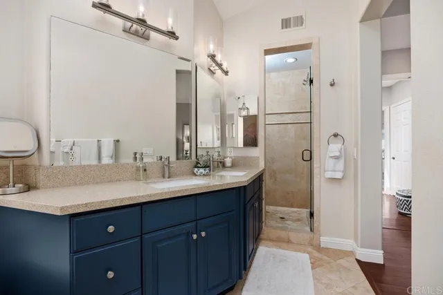 a bathroom with a double vanity sink mirror and shower