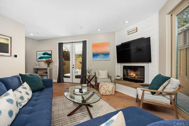 a living room with furniture a flat screen tv and a fireplace
