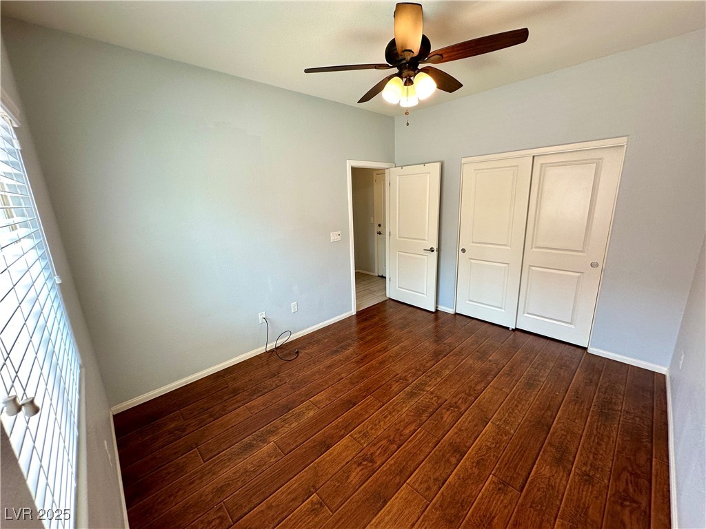 9527 Ridgeglen Court Las Vegas, NV 89148 - Photo 12 of 30 Unfurnished bedroom featuring dark wood-style floors, a closet, and a ceiling fan