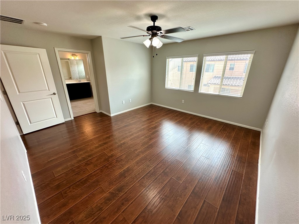 9527 Ridgeglen Court Las Vegas, NV 89148 - Photo 24 of 30 Unfurnished bedroom featuring dark wood-style floors, connected bathroom, a textured ceiling, and ceiling fan