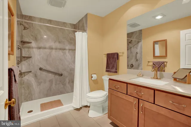 a bathroom with a sink a toilet and a large mirror