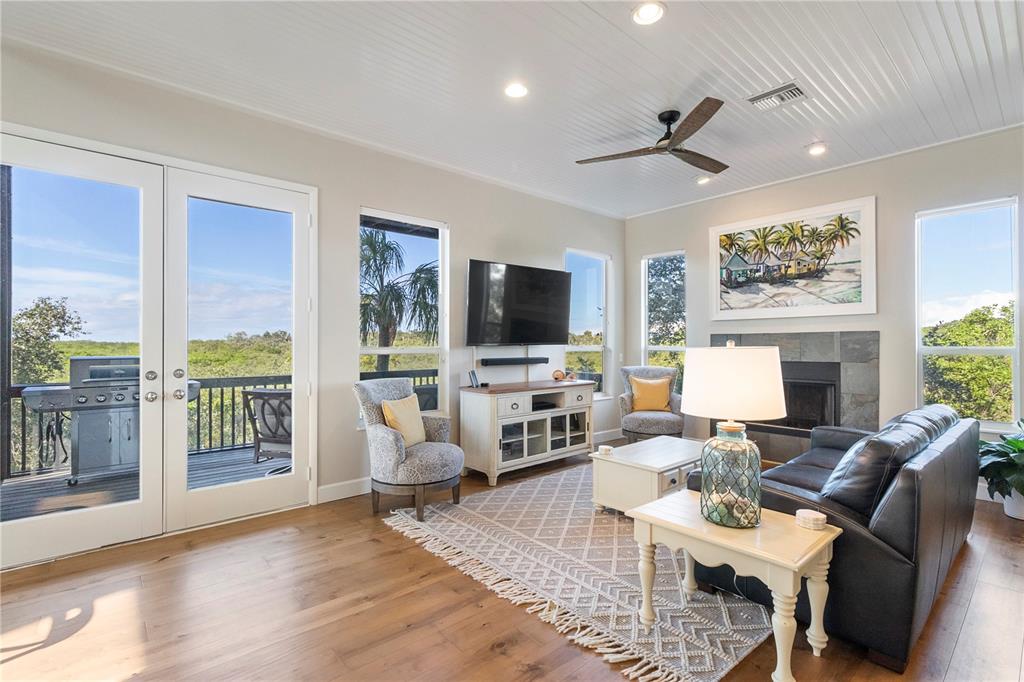 7325 Holly Road Terra Ceia, FL 34250 - Photo 13 of 87 a living room with furniture a flat screen tv and a floor to ceiling window