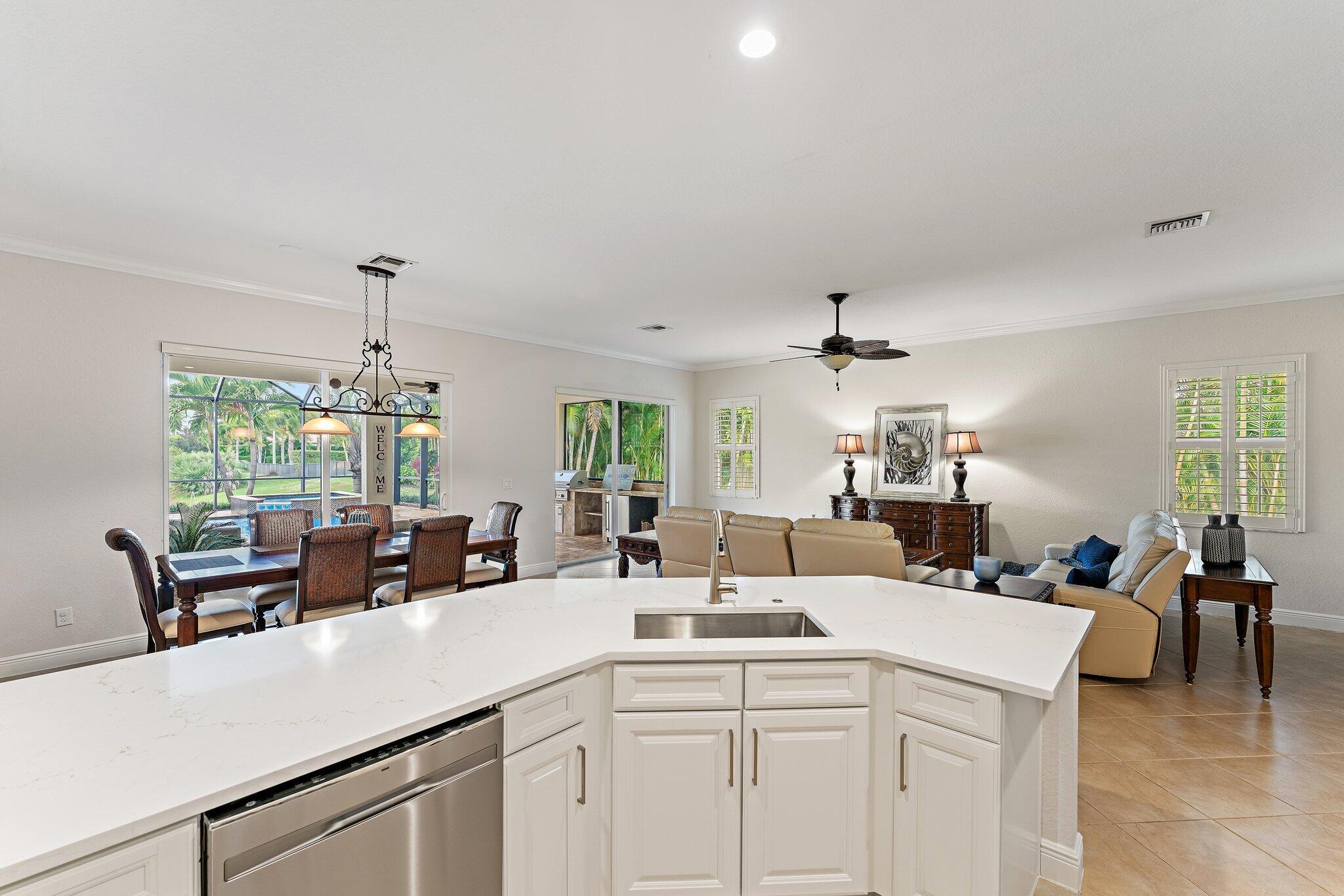 266 Rudder Cay Way Jupiter, FL 33458 - Photo 34 of 79 a kitchen with a sink dishwasher a dining table and chairs with wooden floor