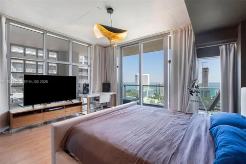 a bedroom with a large bed and a flat screen tv