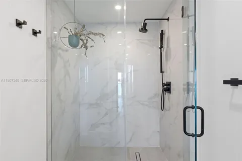 a bathroom with a sink and mirror with bathtub