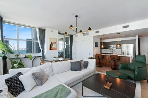 a living room with furniture and a chandelier