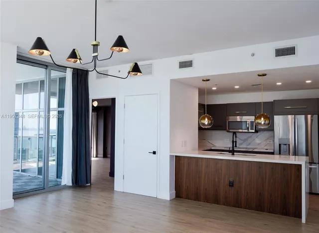 a kitchen with stainless steel appliances granite countertop a refrigerator and a sink