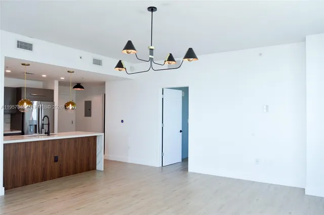 a view of a kitchen with wooden floor and electronic appliances