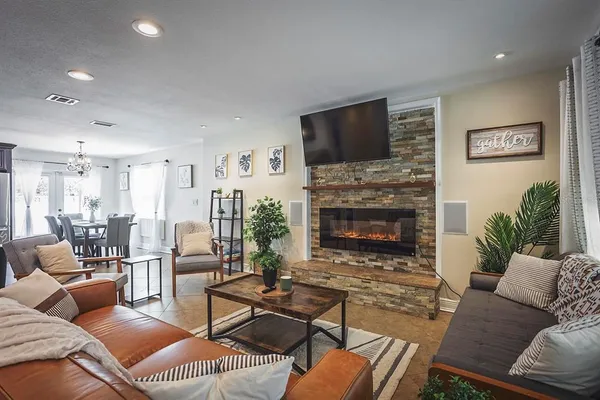 a living room with furniture a flat screen tv and a fireplace