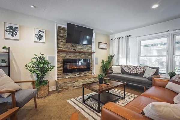 a living room with furniture a flat screen tv and a fireplace
