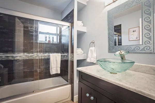 a bathroom with a granite countertop sink a toilet and bathtub