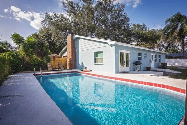 a view of a house with swimming pool and sitting area