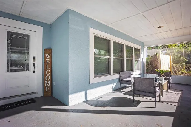 a living room with furniture a flat screen tv and a large window