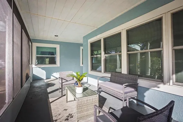 a balcony with couple of chairs and a table