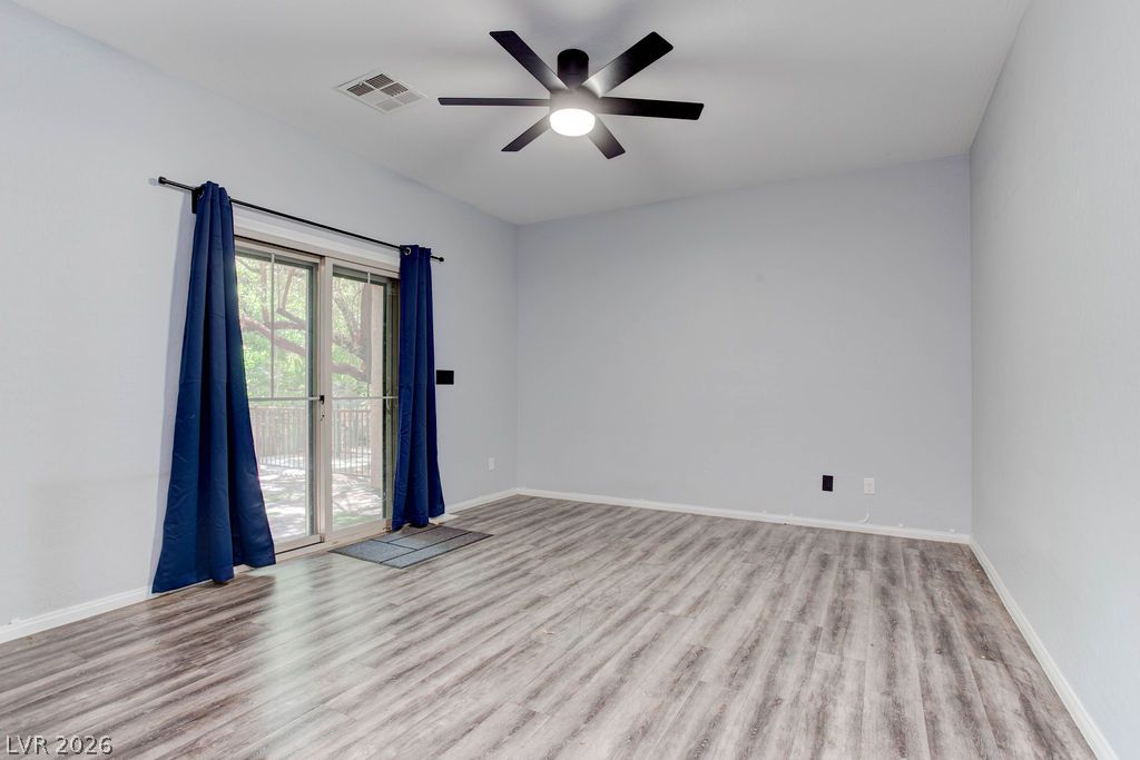 7724 Vibrant Thread Court Las Vegas, NV 89149 - Photo 2 of 43 A comfortable living space featuring durable vinyl plank flooring and convenient sliding doors opening to the outdoors.