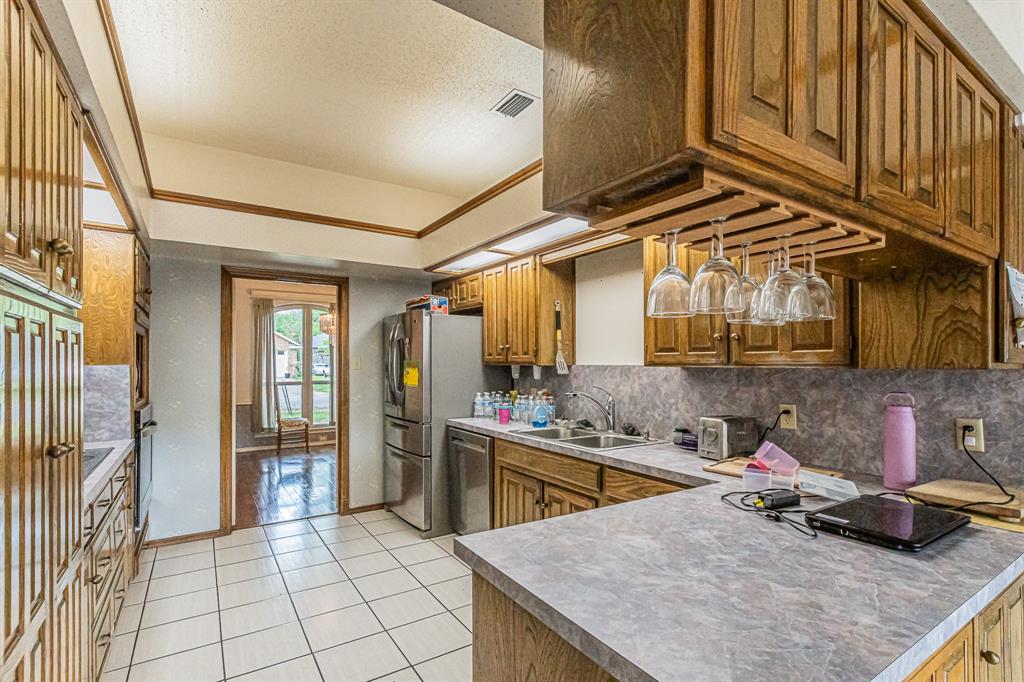 3309 Timber View Circle Bedford, TX 76021 - Photo 10 of 38 a kitchen with a sink a stove and cabinets