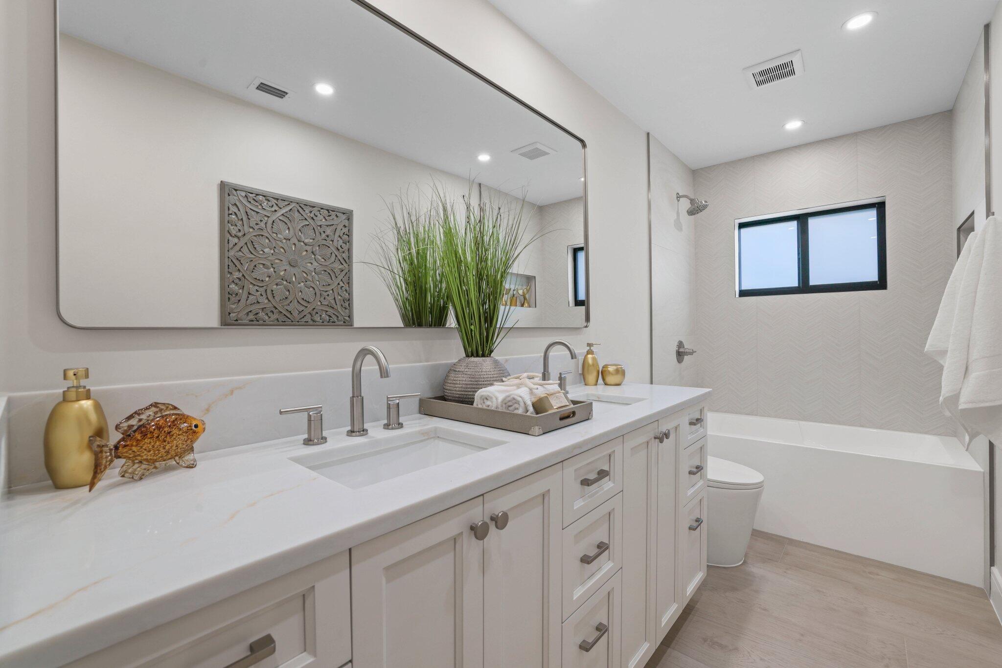 3901 Northwest 27th Avenue Boca Raton, FL 33434 - Photo 42 of 56 a bathroom with double vanity sinks a large mirror and a shower