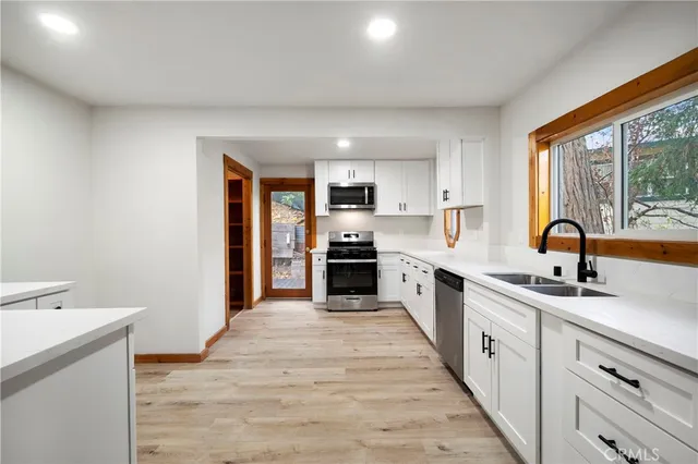 a large kitchen with granite countertop a large counter top space appliances and windows