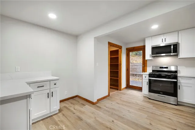 a kitchen with granite countertop a refrigerator and a stove top oven