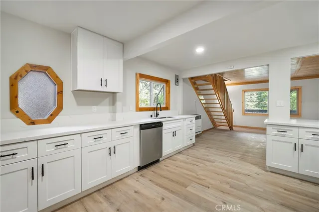 a large kitchen with granite countertop a stove a sink and a large window