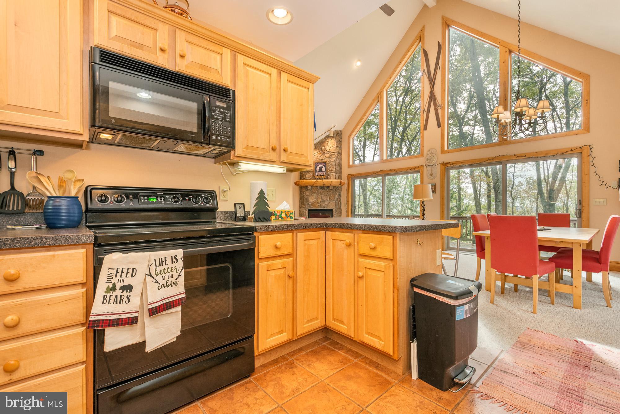 31 Linz Lane Swanton, MD 21561 - Photo 22 of 51 a kitchen with stainless steel appliances granite countertop a stove top oven a dining table and chairs with wooden floor
