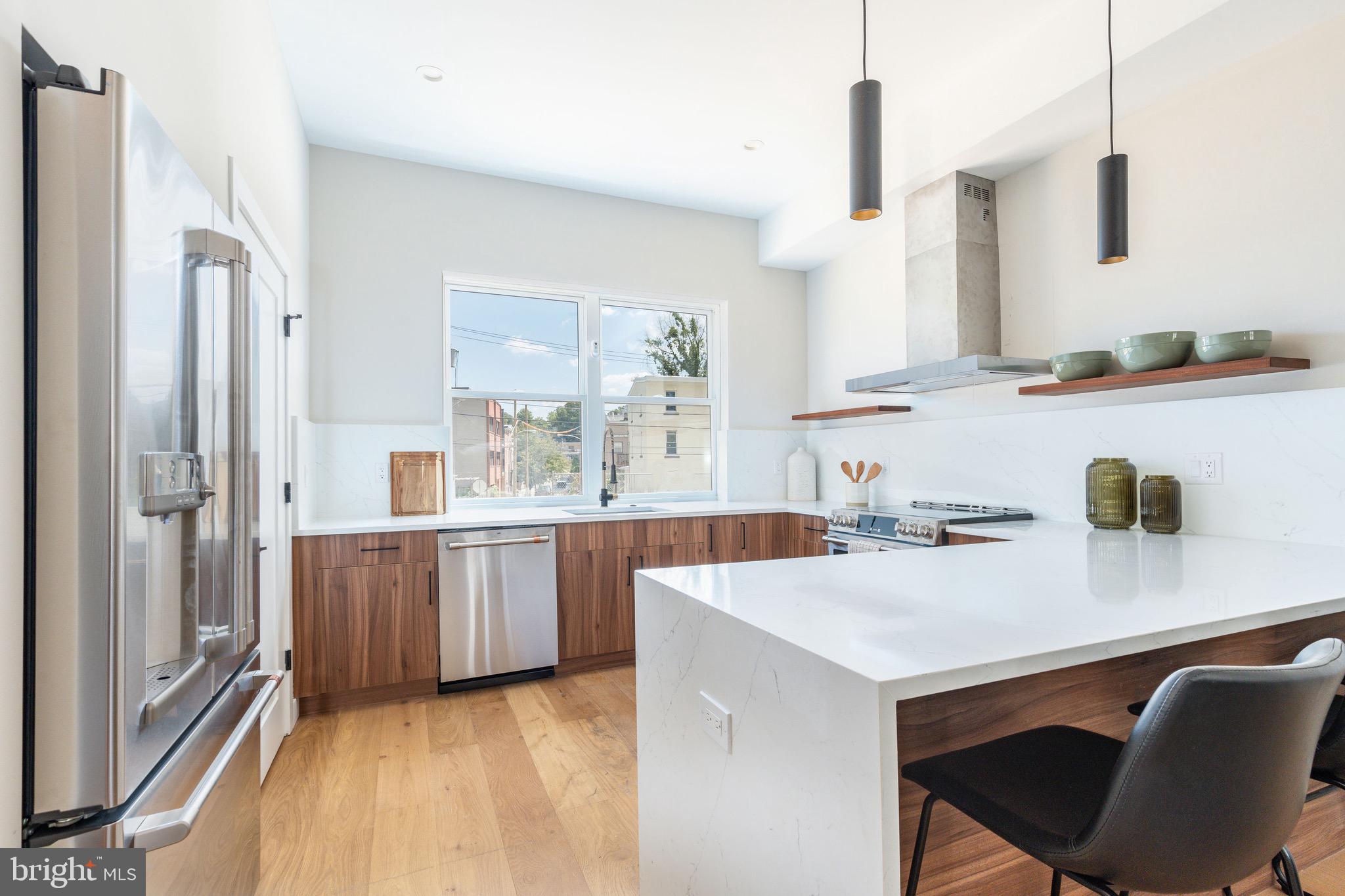 a kitchen with a sink a stove a refrigerator and white cabinets