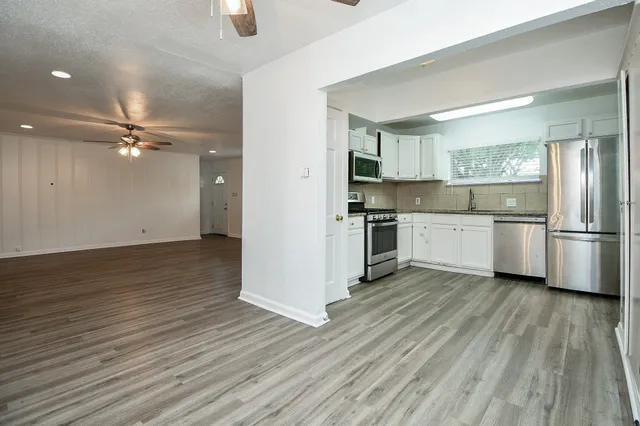 a view of kitchen with wooden floor electronic appliances and window