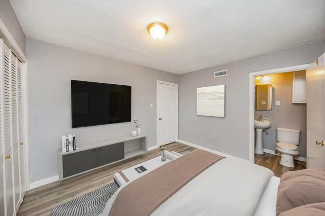 a bedroom with a bed and a flat screen tv