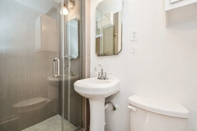 a bathroom with a sink toilet and mirror