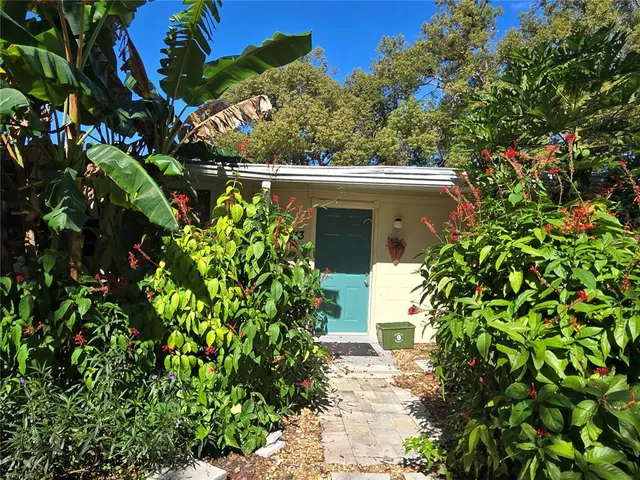 a view of a house with backyard water fountain and sitting area