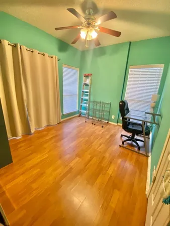 a view of a room with wooden floor and windows