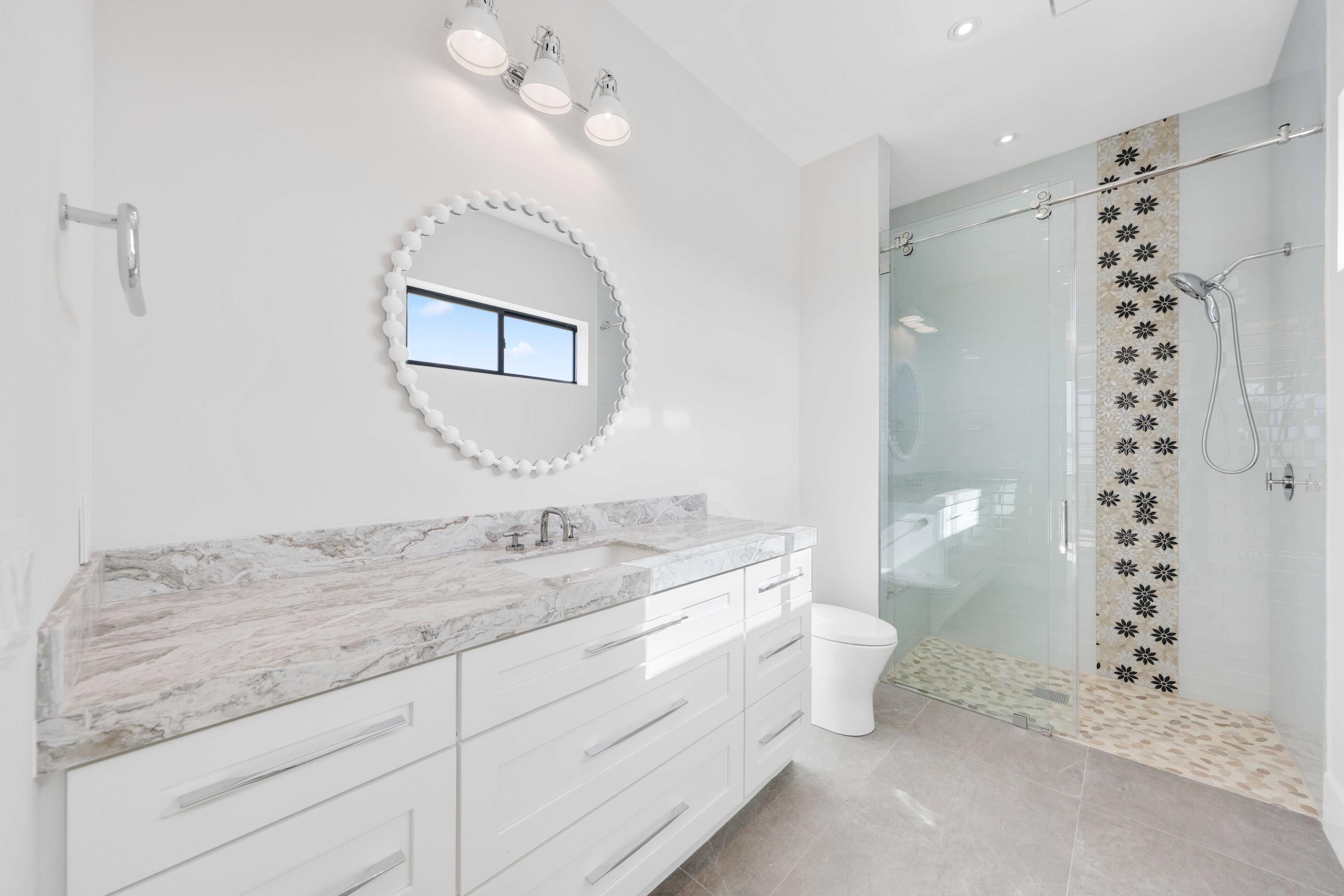 151 Eden Ridge Lane Boynton Beach, FL 33435 - Photo 41 of 74 a spacious bathroom with a granite countertop sink a toilet and a mirror