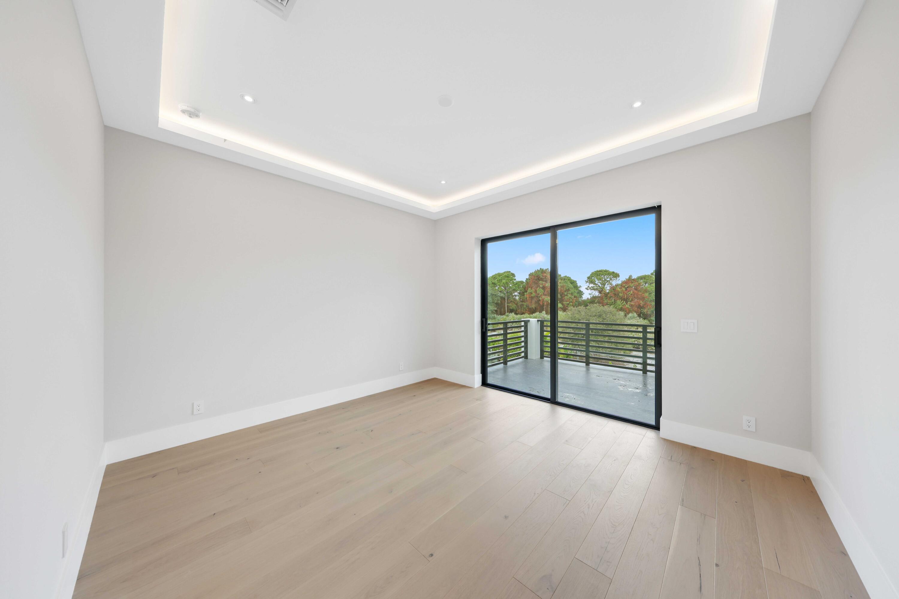 151 Eden Ridge Lane Boynton Beach, FL 33435 - Photo 47 of 74 an empty room with wooden floor and a floor to ceiling window