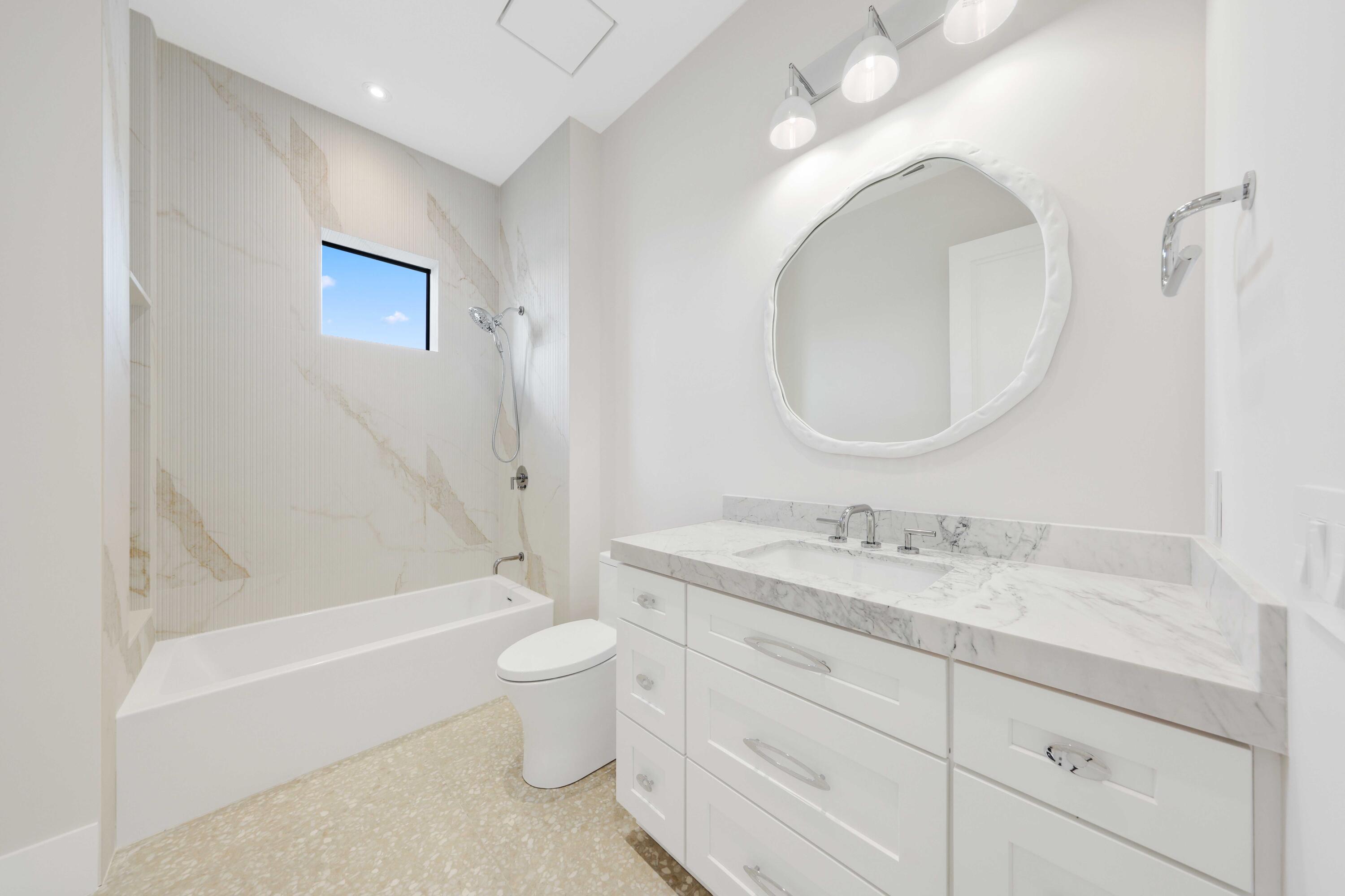 151 Eden Ridge Lane Boynton Beach, FL 33435 - Photo 49 of 74 a bathroom with a toilet a sink a bathtub and a mirror